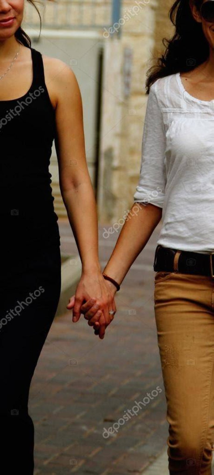 Both are posing holding hands.