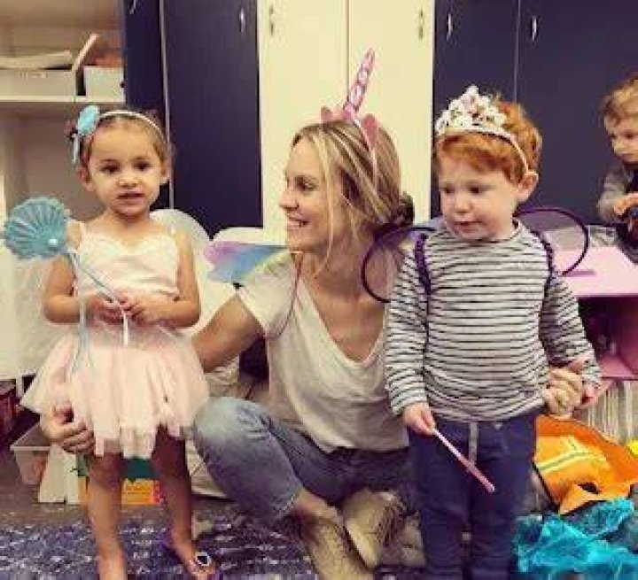 Cassidy Boesch is playing with a boy and a girl dressed as fairies.